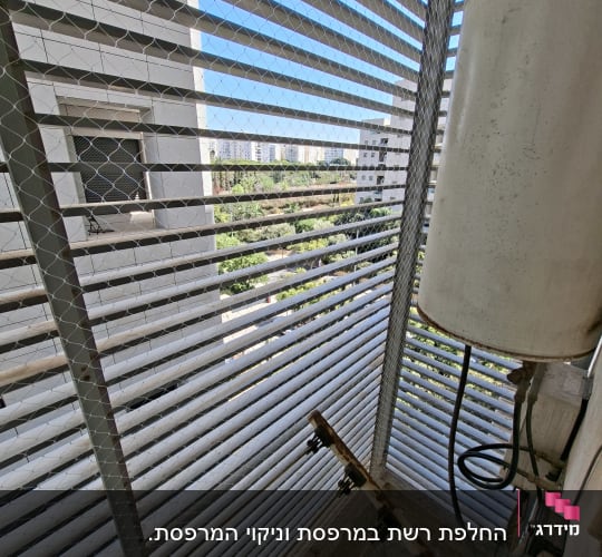 רשת מתכת על מרפסת עם נוף עירוני